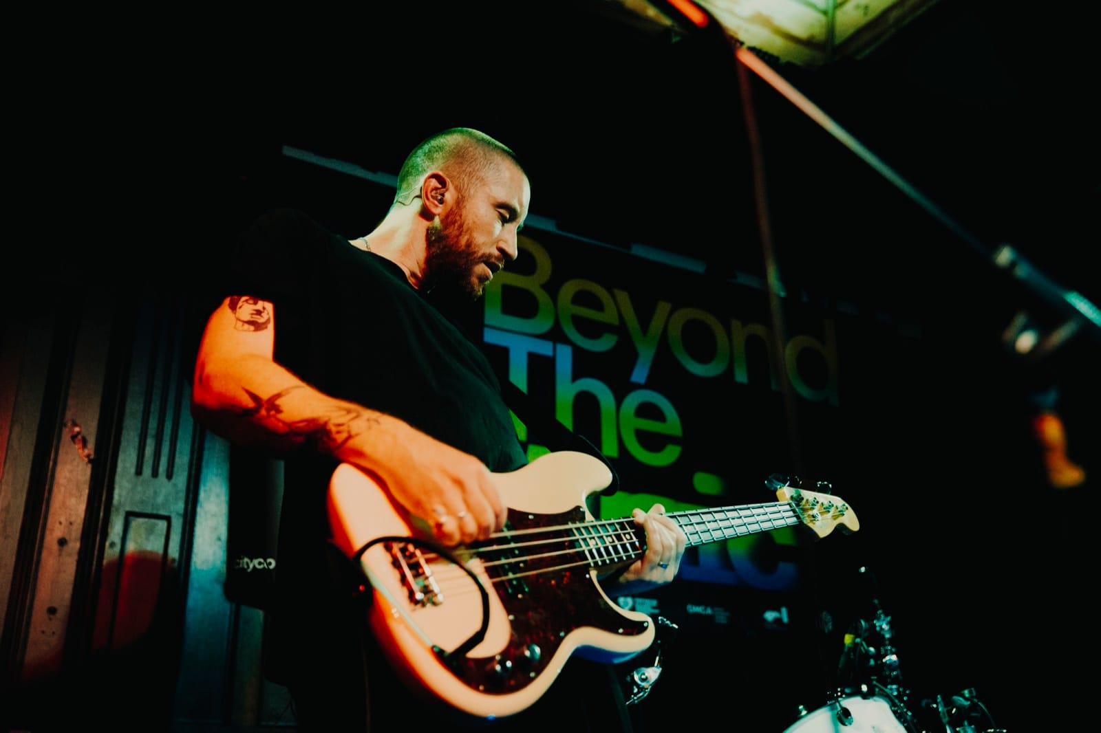 A band performing live on a grassroots stage at Beyond The Music.